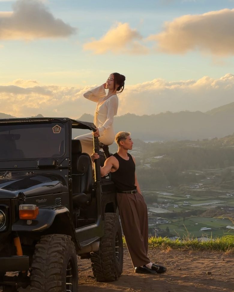 Scott Ho and Seolah on an open jeep on a mountain ridge at golden hour